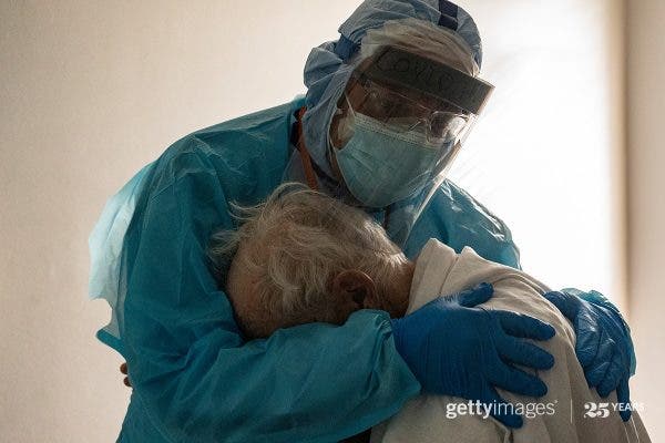 Imagine virală: medic fotografiat în timp ce îmbrățișa un bătrân cu covid