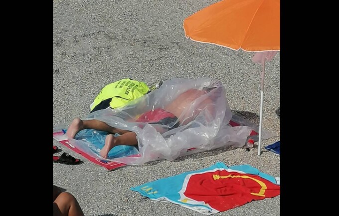 Imagini uimitoare în Eforie Nord. Un bărbat se bronzează într-un sac de plastic