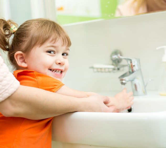 Un copil care se spală pe mâini