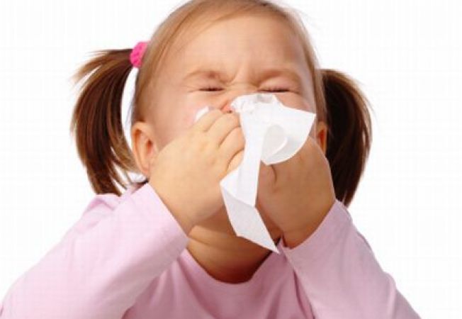copil care isi sufla nasul intr-un servetel