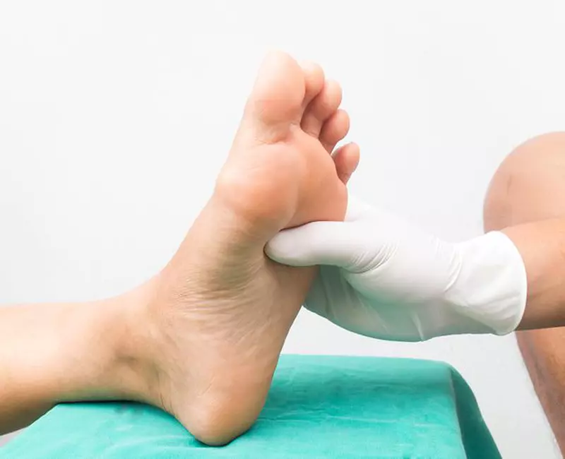 medic care maseaza piciorul unei persoane