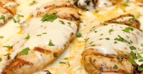 Chicken breast with white sauce and parsley leaves
