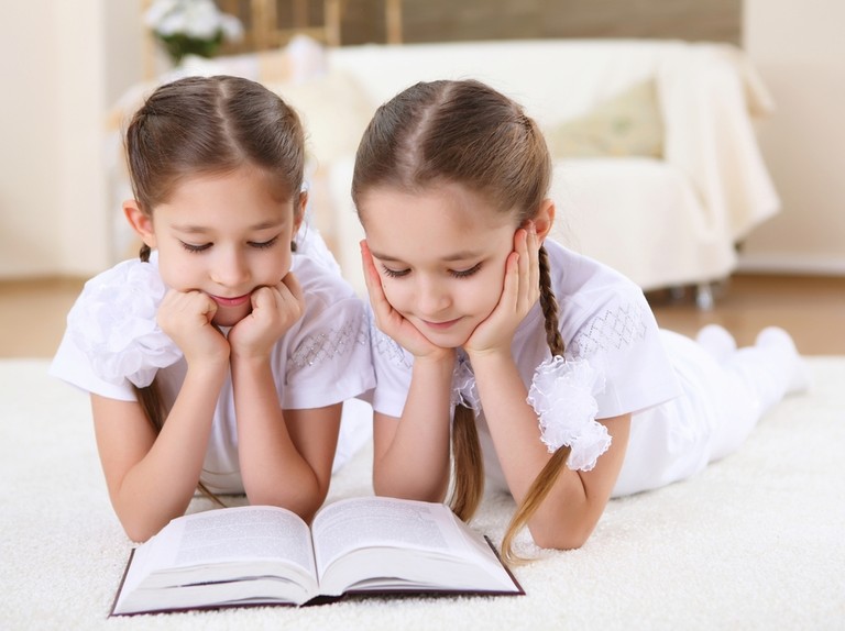 două fete gemene care citesc