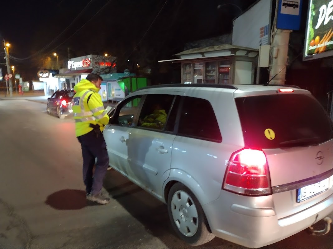 un polițist langa o masina gri pe o strada din Iași