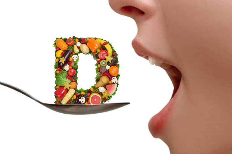 litera d din legume si fructe pe o lingura langa o femeie care sta cu gura deschisa