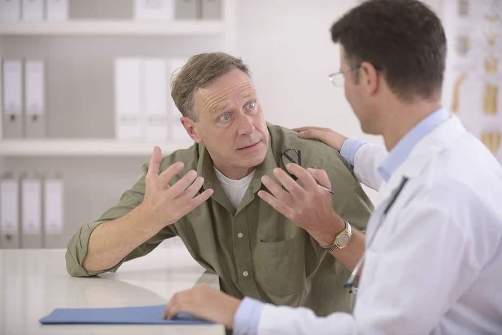 un bărbat stă de vorbă cu un medic