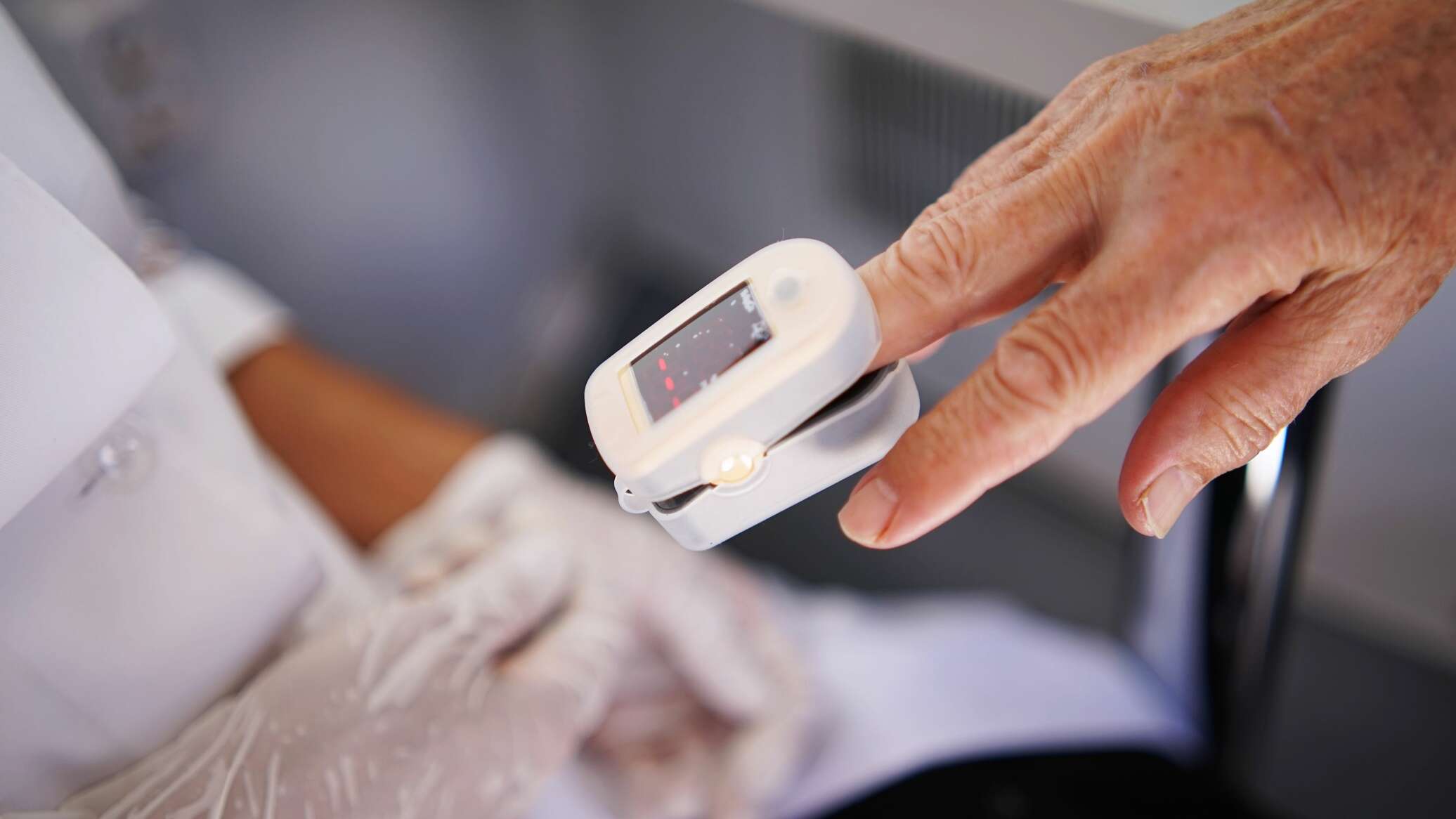 medic care verifica cu un pulsioximetru saturatia de oxigen din sange a unei persoane