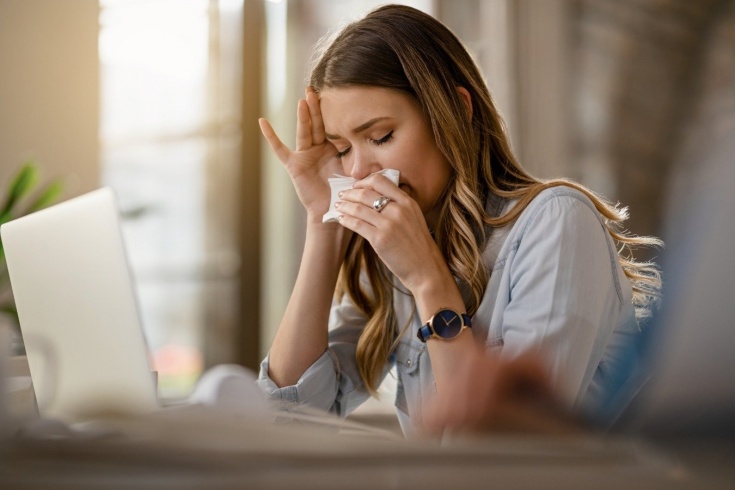 femeie care tine un servetel la nas din cauza alergiei