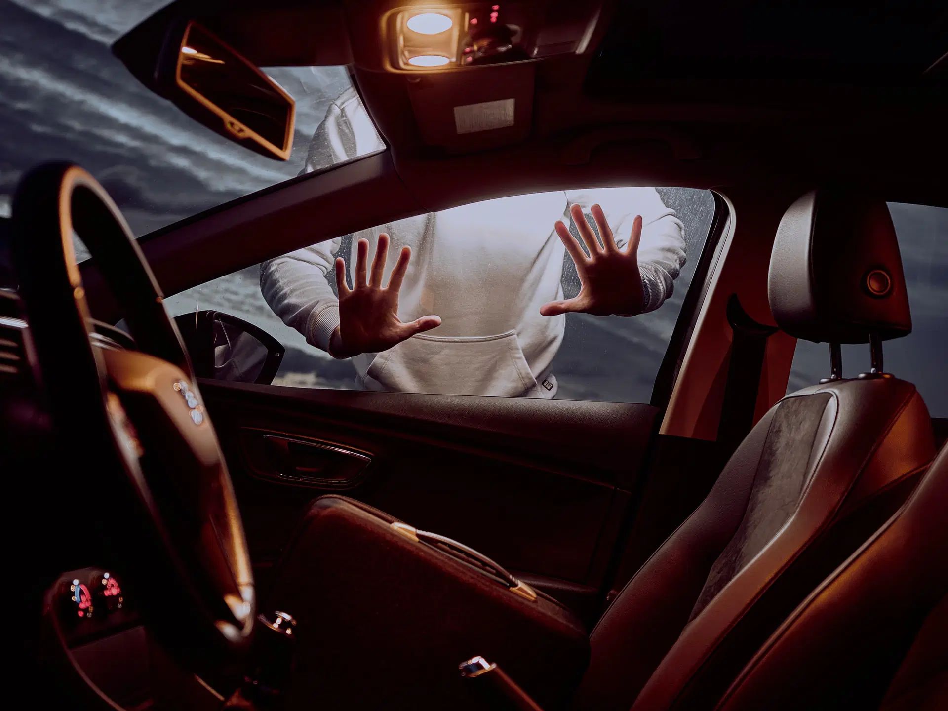 interiorul unei masini si o persoana in exterior cu mainile pe geam