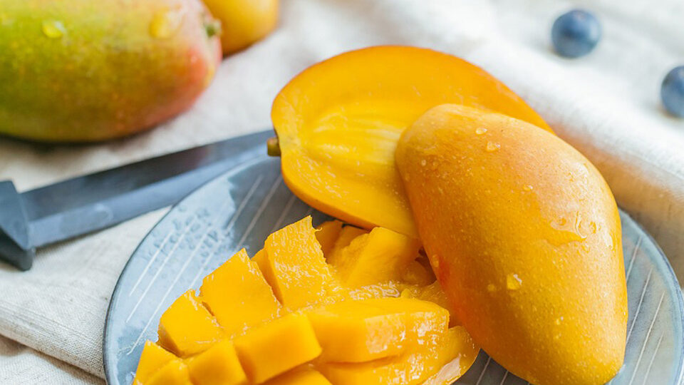 mango taiat si mango intreg pe o masa
