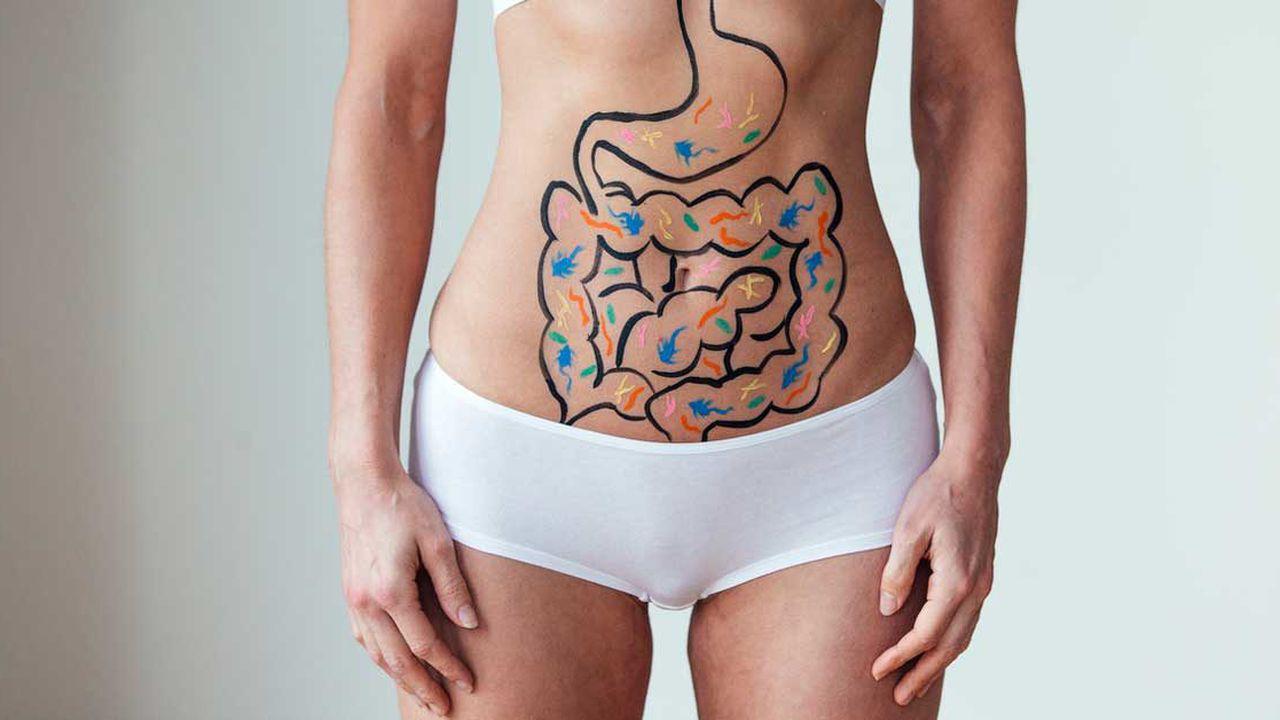 femeie care are desenat pe abdomen sistemul gastrointestinal plin cubacterii