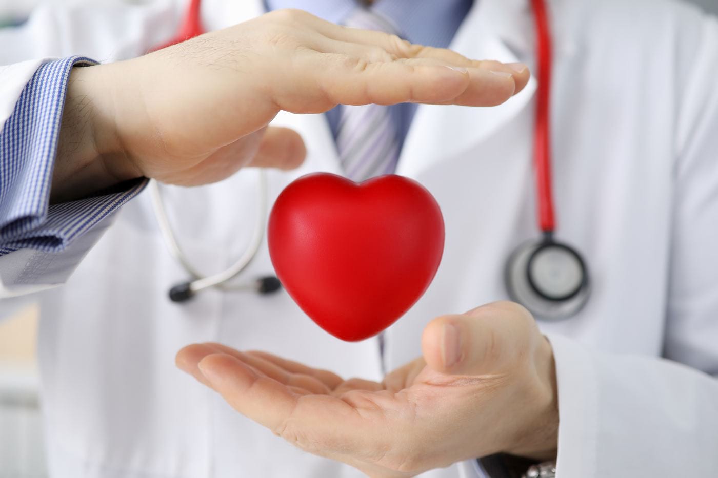 un medic care ține o inimă roșie în mâini
