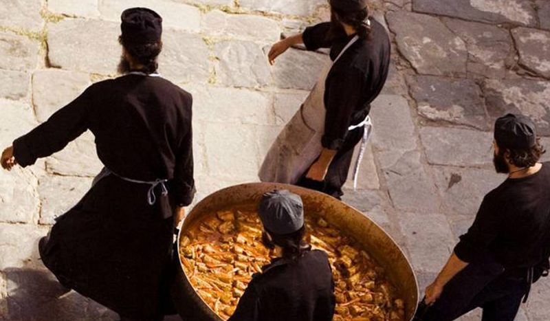 patru călugări care cară o oală cu mâncare