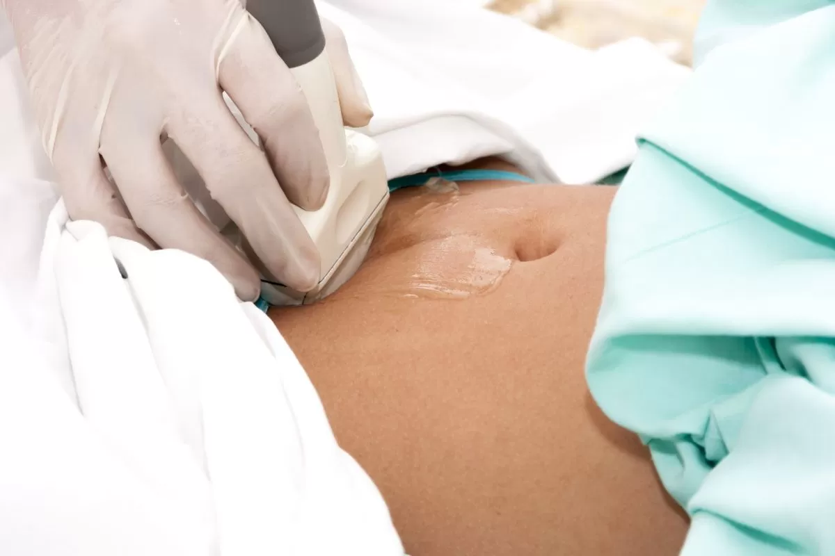medic care efectueaza o ultrasonografie a abdomenului unei persoane
