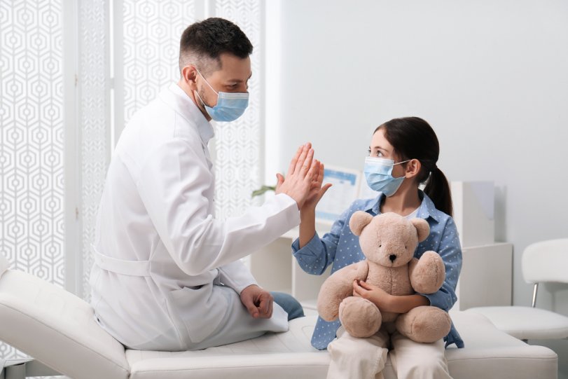 medic care da palma cu un copil care tine in mana un ursulet