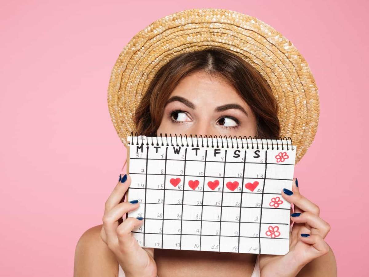 woman holding a calendar in which the period of the menstrual cycle is marked