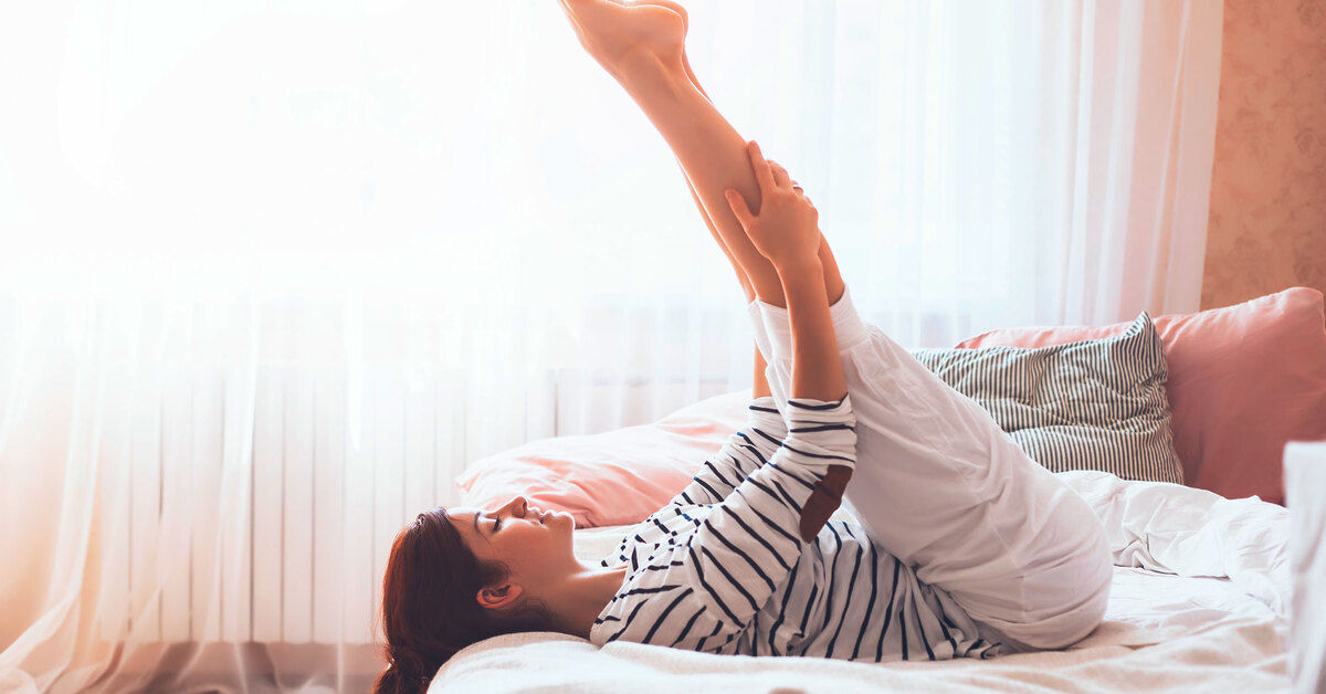 femeie care face exercitii fizice in pat