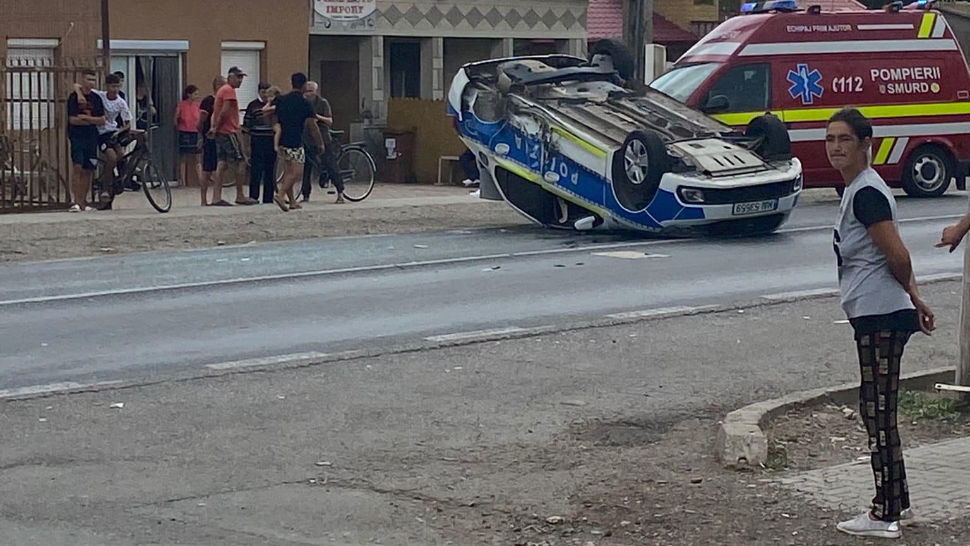 Mașină de poliție răsturnată de un șofer grăbit care a ieșit din benzinărie. Polițistul a fost transportat la spital