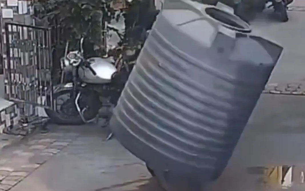 Miracol pe stradă: Femeie scapă nevătămată după ce un rezervor masiv de apă cade direct peste ea