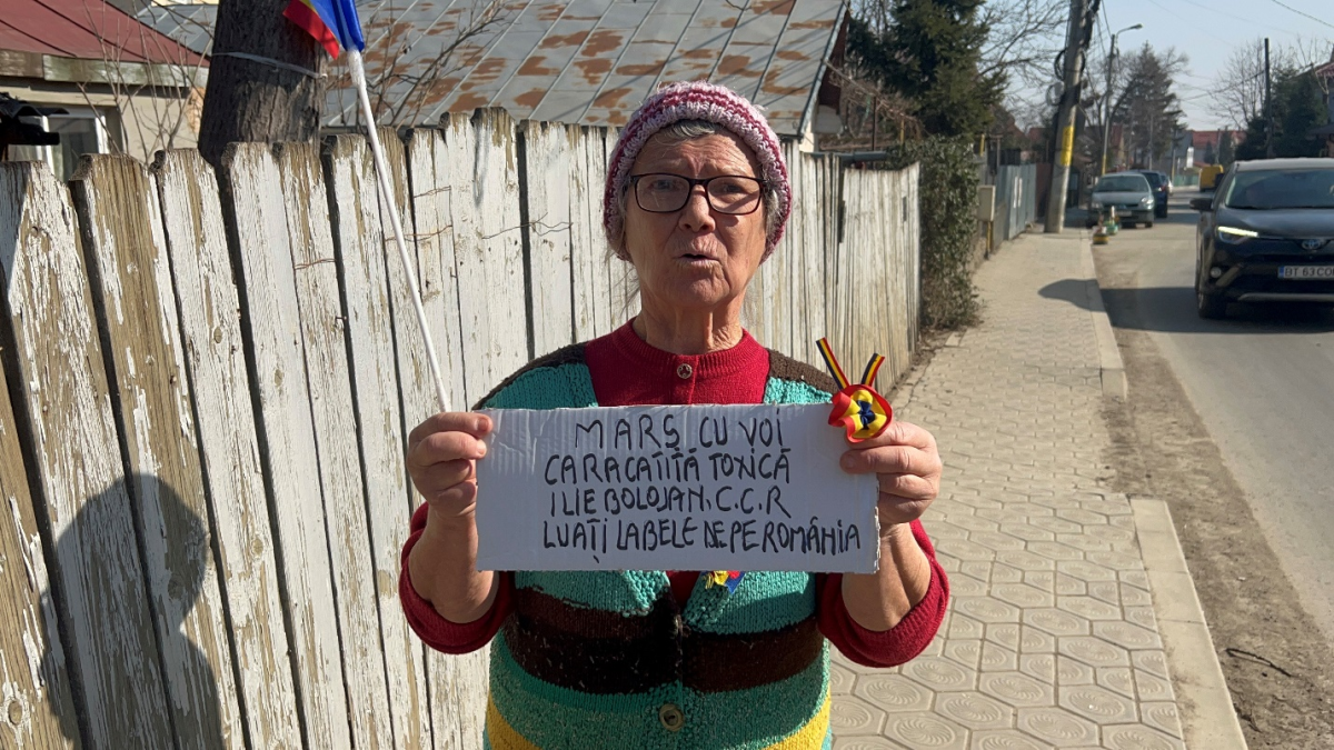 Protest neobișnuit în Tătărași! O fostă asistentă de la Infecțioase își strigă nemulțumirea în fața casei, cu drapelul în mână. Există o dilemă: nu știe contra cui este